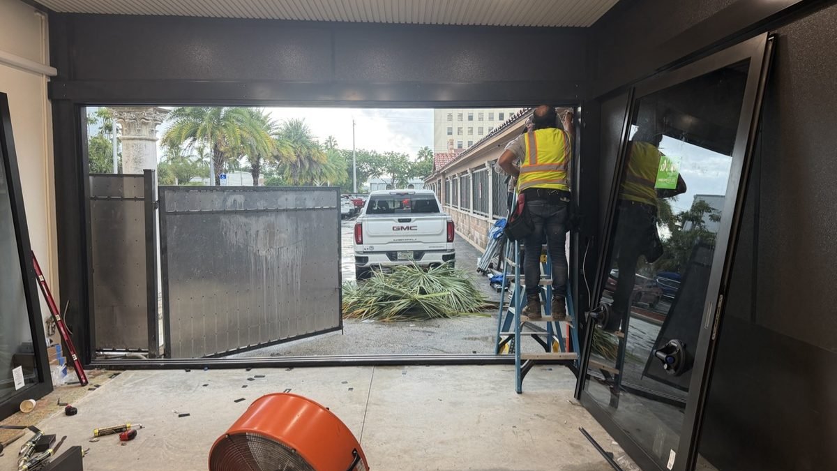 Installation crew fitting a new door and window unit