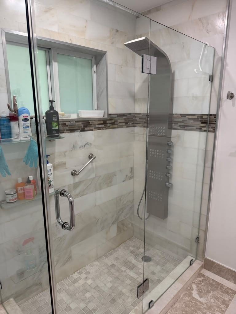 Glass shower door hinge and panel being serviced